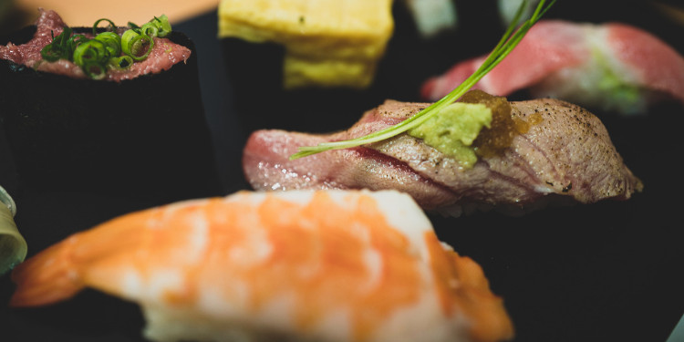 Sushi variado com camarão, carne e omelete em close-up.