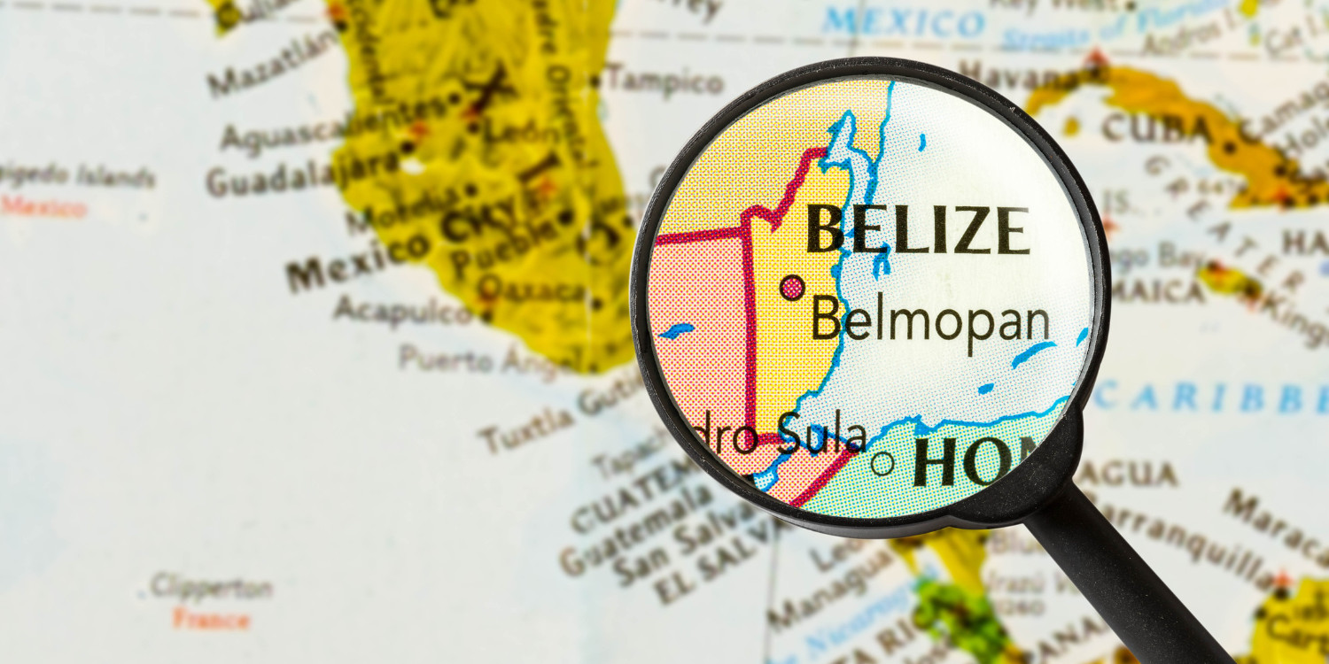 Mapa turístico de Belize com lupa destacando o país, convidando à exploração e viagem.